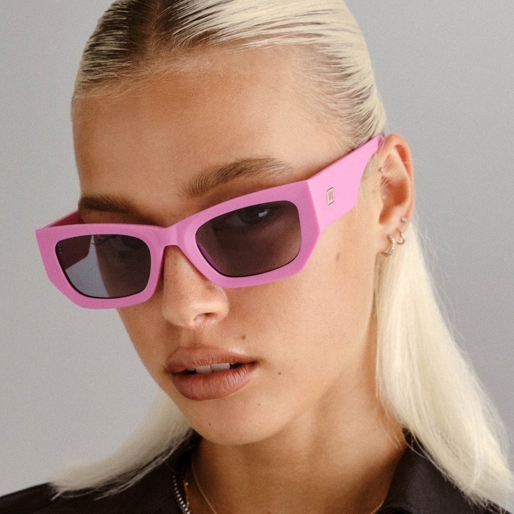 Le Specs. Smoke tinted lenses within a bubblegum pink, matte frame.